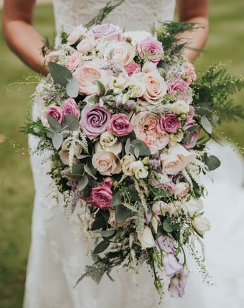 pink lilac and white bouquet filled with roses and lisianthus for bride wearing Christina Wu dress