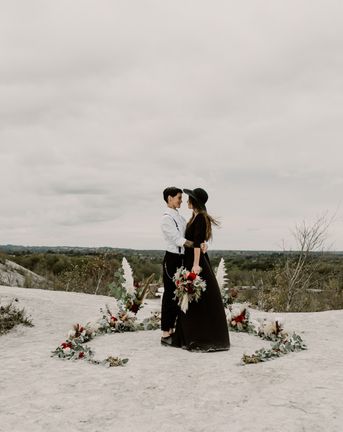 Black Wedding Dress for Wild Same-Sex Couple Wedding Inspiration | Pampas Grass, Eucalyptus & Red Rose Horseshoe Floral Design | Anne Letournel Photography