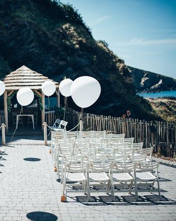 Gypsophila Arch and Giant Balloons for an Outdoor Coastal Wedding | Strapless Pronovias Ballgown Dress | ASOS Bridesmaids Dresses | Toby Lowe Photography