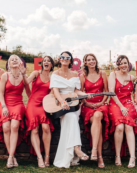Bride in an ASOS wedding dress with bridesmaids in bright red dresses.