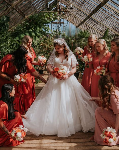 Bride in a princess tulle wedding dress with the bridesmaids in coral peach bridesmaid dresses.