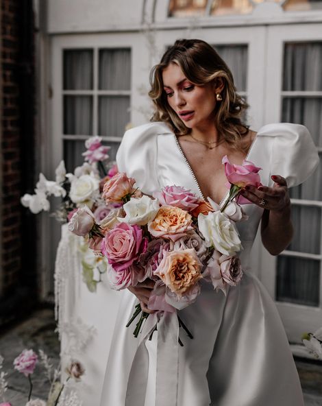Bride holding a colourful pink and white rose wedding bouquets 