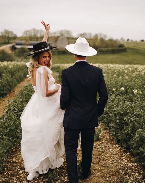Country theme Stone Barn wedding with bride and groom wearing cowboy hats