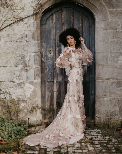 Black bride with afro hair in a 3D flower pink embroidered wedding dress at Chiddingstone Castle