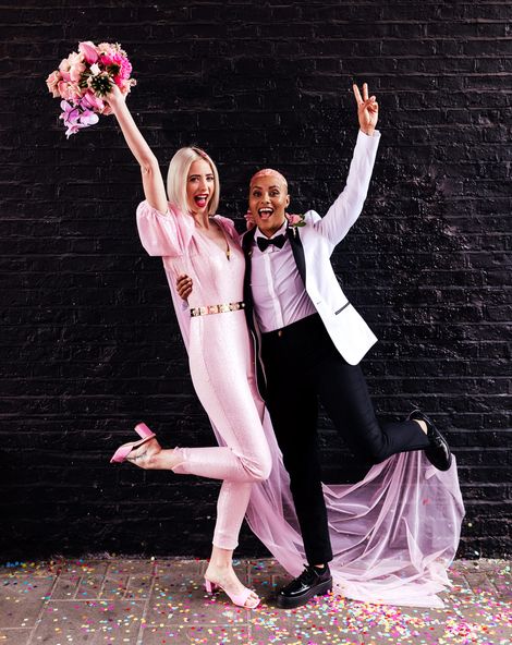 Alternative wedding inspiration with two brides in a pink jumpsuit and white tuxedo jacket 