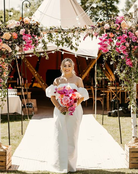 Tipi wedding with the bride in off the shoulder dress holding pink bouquet