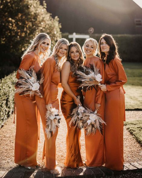 Round-up of orange bridesmaid dresses  in burnt orange, citrus and apricot shades, and satin, chiffon and patterned fabrics. 