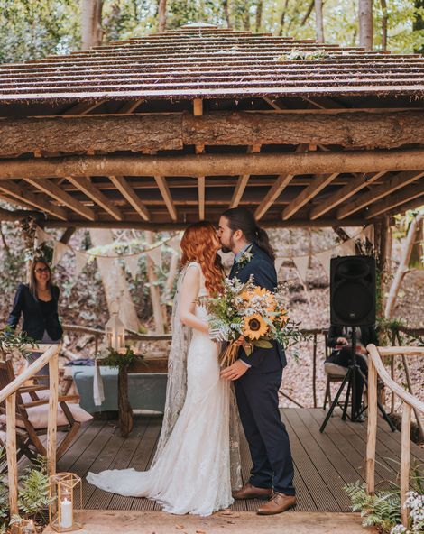 Outdoor forest wedding with sunflower wedding bouquet, embroidered veil and lace wedding dress.