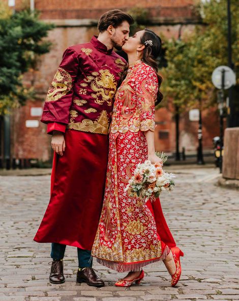 Bride and groom in traditional red and gold Chinese wedding attire for multicultural city wedding in Manchester