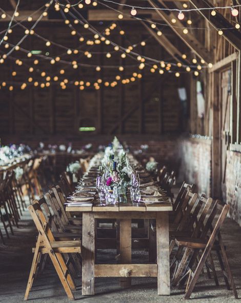 Rustic wedding ideas with fairy lights, trestle tables, tree slices, flowers in jars and wooden signs 
