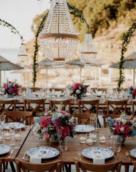 beach bar wedding in Greece with boho wedding dress and pink and blue wedding flowers 