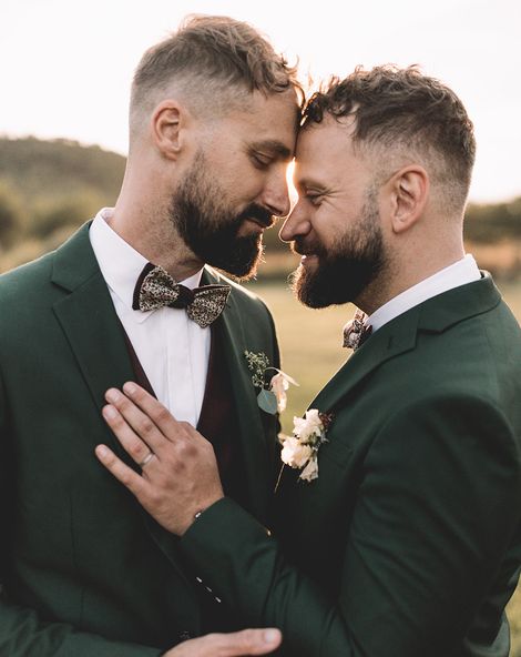 Grooms pose together in their dark green suits for their secular ceremony.