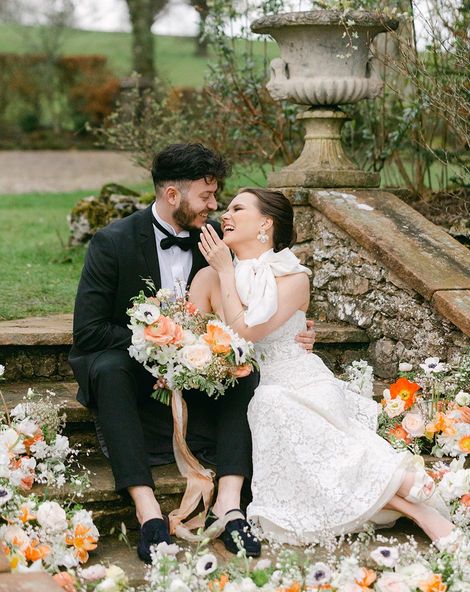 Romantic Holesfoot wedding inspiration with orange and white flowers, lace and beaded wedding dresses and an iced wedding cake