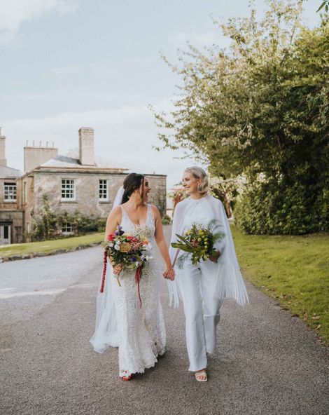 LGBTQI+ wedding with bride in handmade bridal jumpsuit with cape for five day long wedding adventure