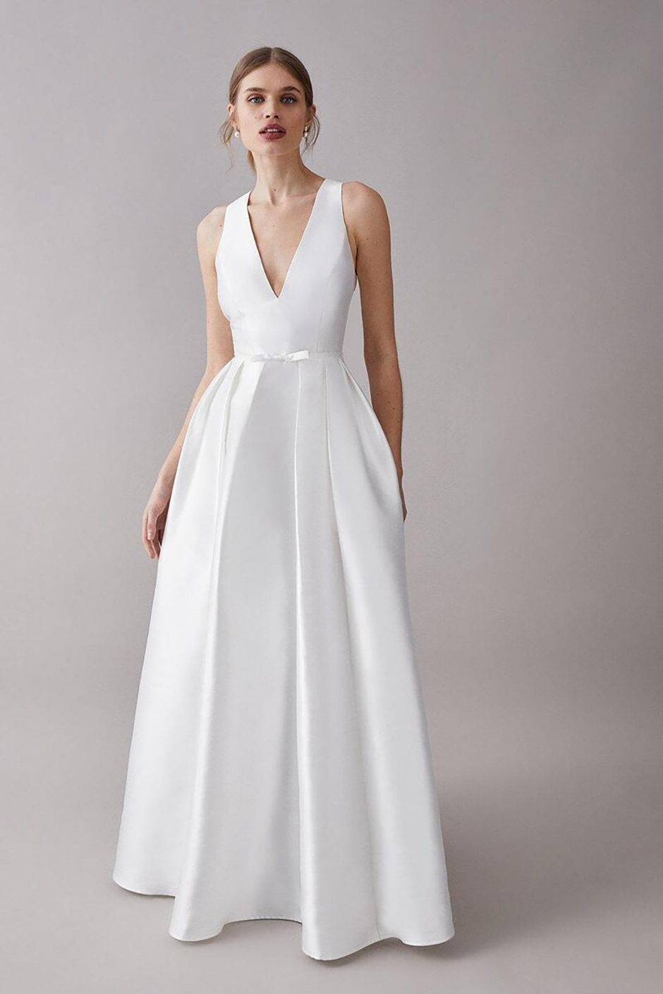 Traditional wedding dress with pockets, a plunge neckline and minimal bow at the waist from Coast and Debenhams 
