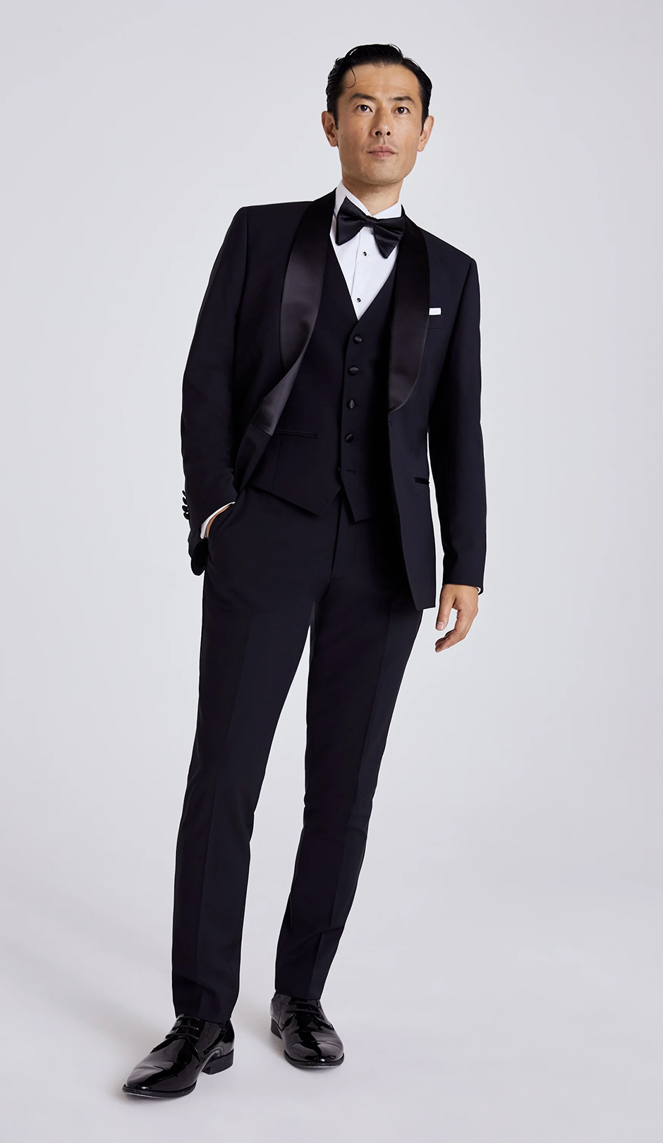 Moss Bros model wearing black tie wedding suit for groom
