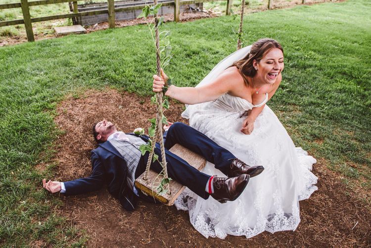 kevin fern photography bride and groom play on a swing