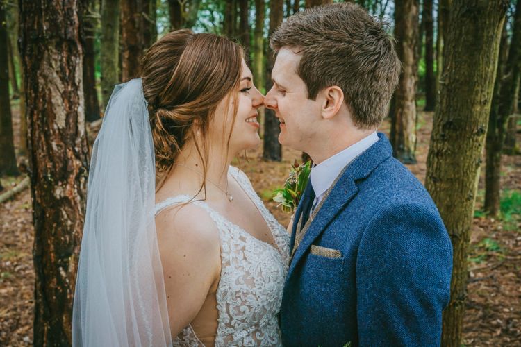david lefebvre photography intimate moment with english couple in countryside at woodland wedding venue surrounded by trees smiling at each other in tweed suit and classic buttoned dress by photographer david lefebvre