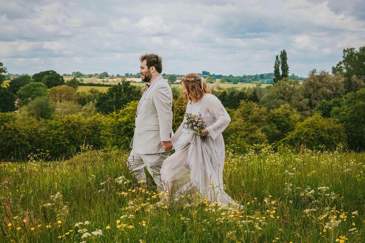 david lefebvre photography newly married couple walking through green somerton meadow with uk country landscape after wedding taken by buckinghamshire photographer david lefebvre for rock my wedding