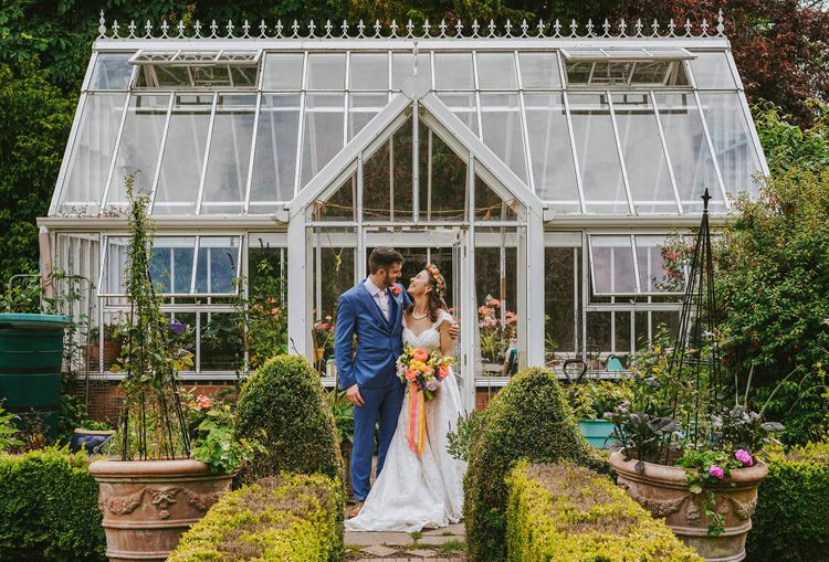 david lefebvre photography bride and groom at rustic boho wedding at plum park hotel manor in towcester stood outside large green house in vibrant garden taken by buckinghamshire photographer david lefebvre rock my wedding