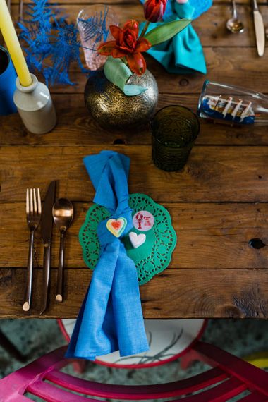 Place setting with green doily and blue napkin