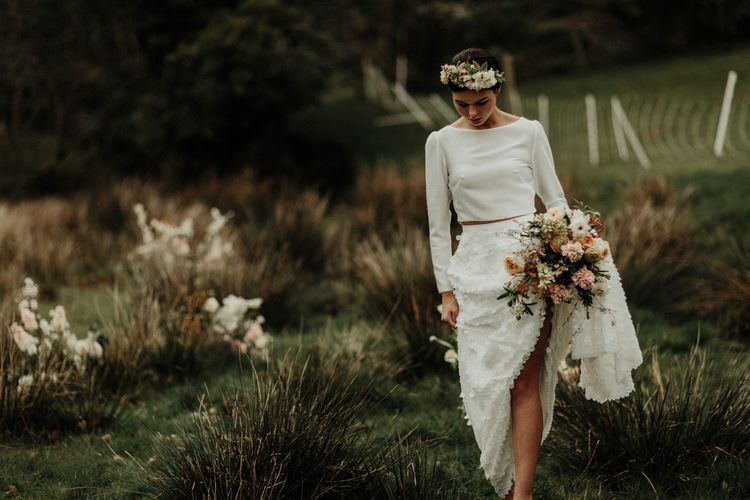 Boho bride in flower down sequin skirt and bridal crop top walking in the Welsh countryside
