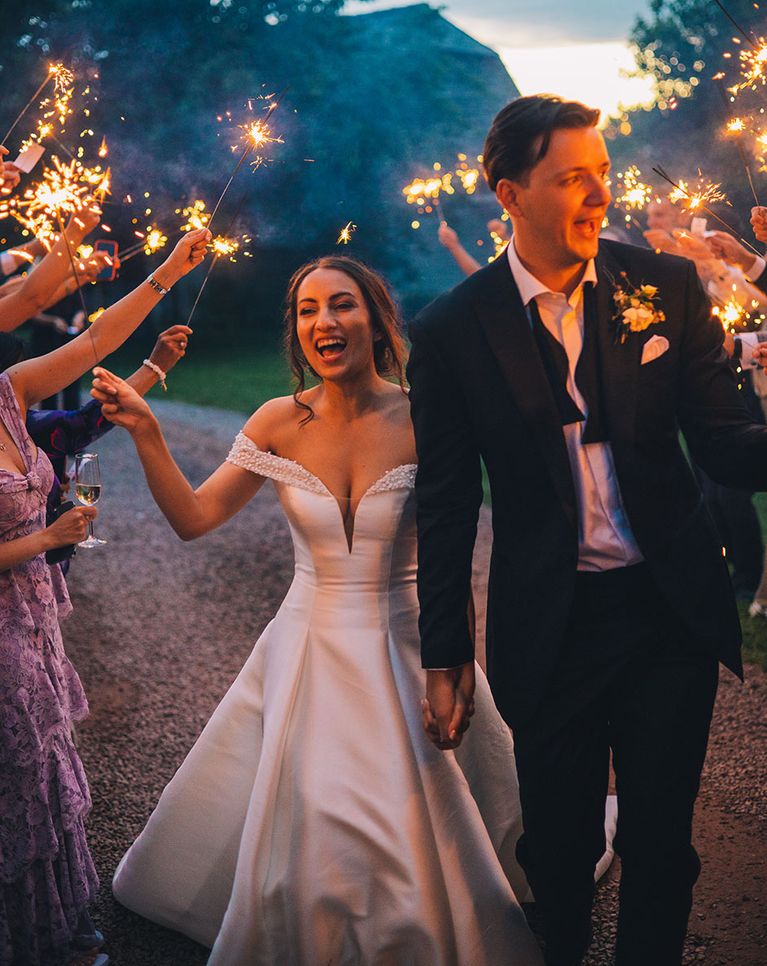 Sparkler exit for bride in sparkly Pronovias dress and groom in black tie for classic wedding including elegant mint green bridesmaid dresses.